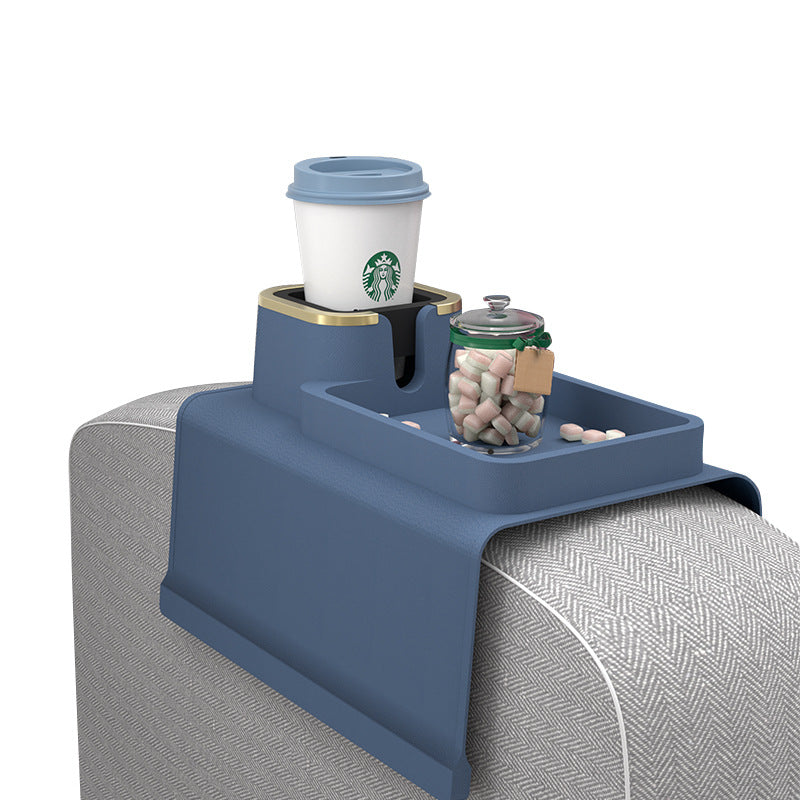 Multifunctional silicone sofa armrest cup holder in blue holding a coffee cup and candy jar, ideal for modern living room convenience.