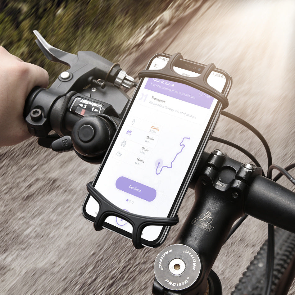 Cyclist using black silicone bicycle phone holder on handlebar, securely holding smartphone with GPS app during outdoor ride.